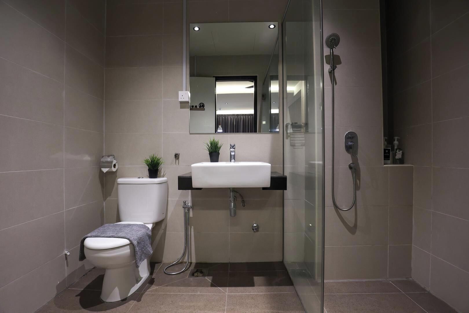 A modern bathroom with a toilet, sink, and shower.