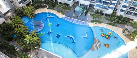 Ein mehrgeschossiges Wohngebäude mit Swimmingpool, der mit Delphin- und Fischmotiven gestaltet ist.