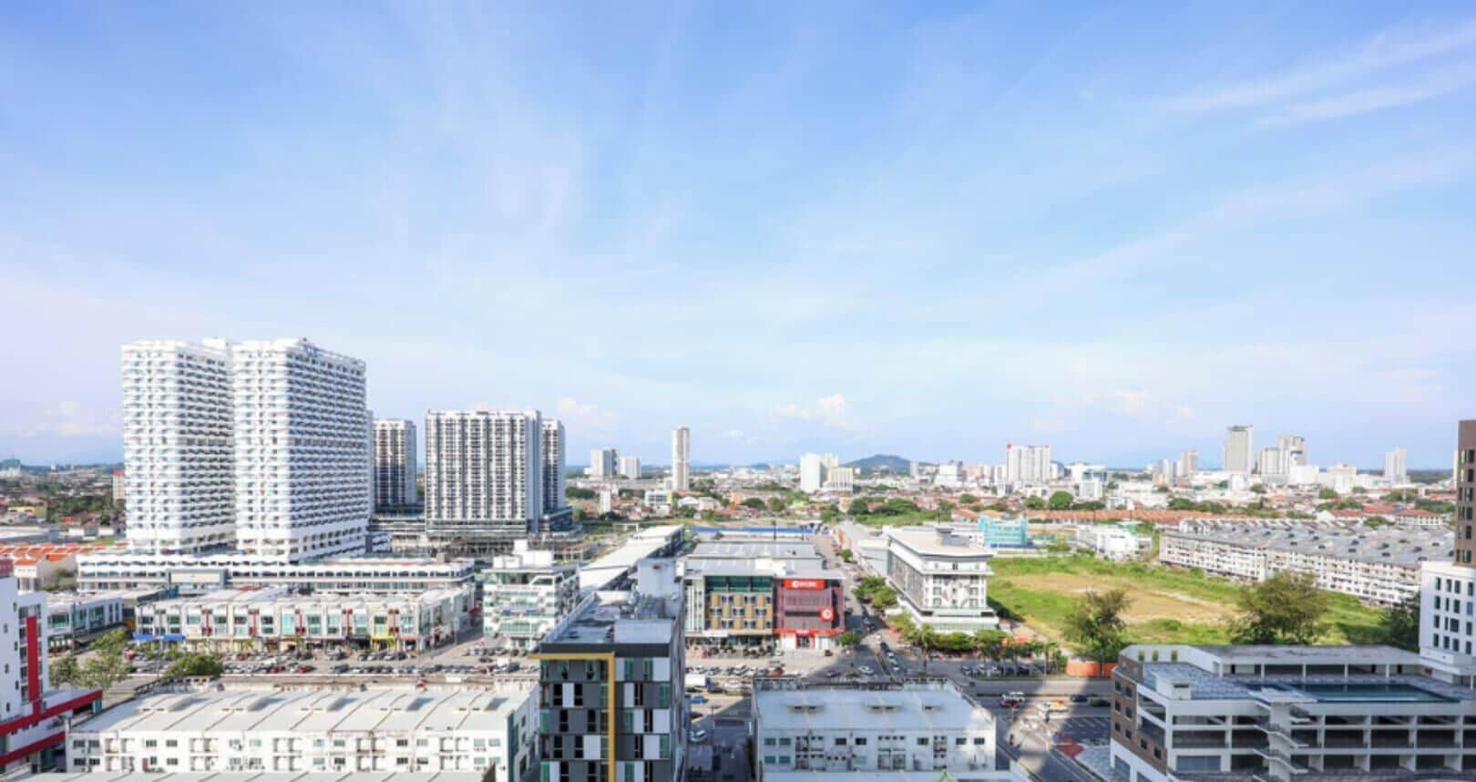 A cityscape with high-rise buildings, a parking lot, and a mix of commercial and residential structures.