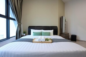Une chambre d’hôtel avec un grand lit, une table de chevet ornée d’une plante et une vue par la fenêtre.
