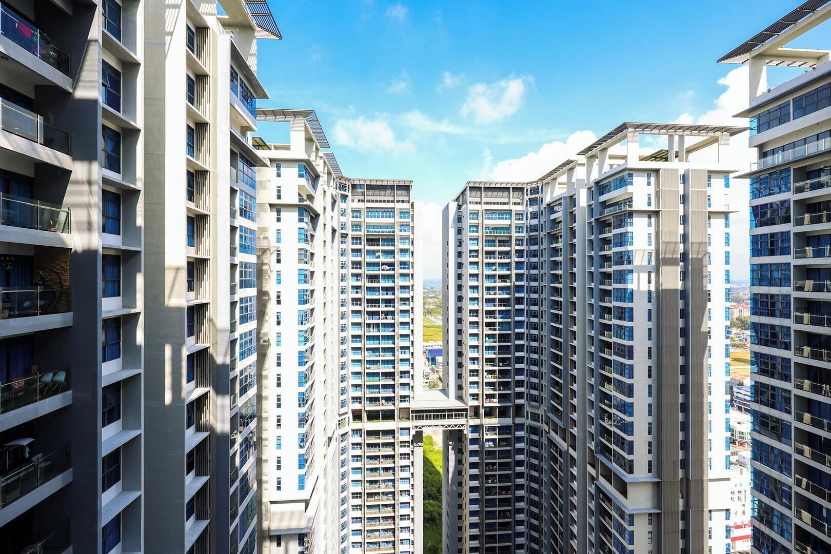 Een hoog appartementencomplex met meerdere balkons en vrij uitzicht op de omgeving.
