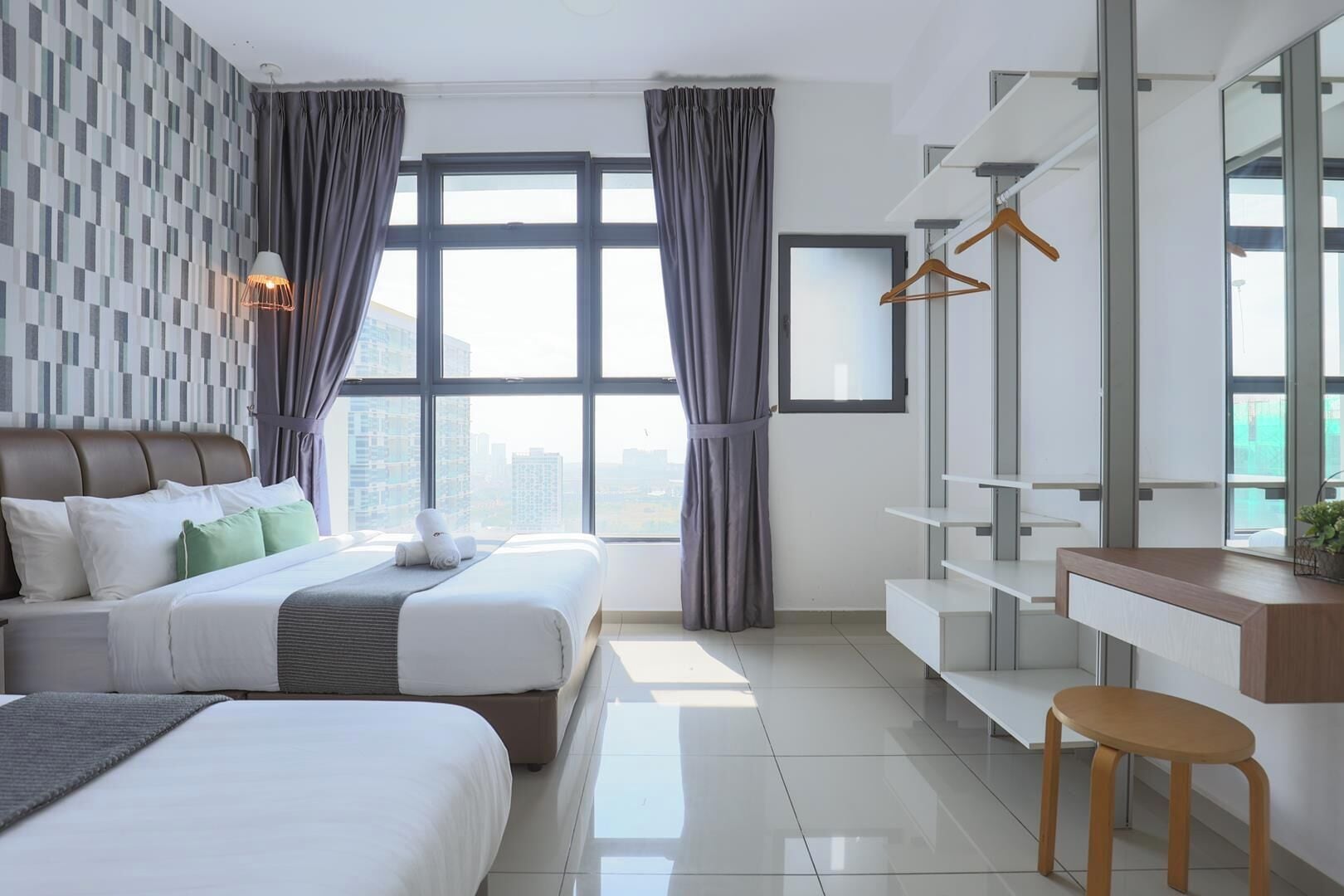 Habitación de hotel moderna con una cama grande, un escritorio y vistas a la ciudad.