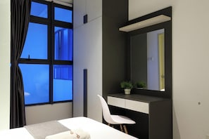 Ein modernes Schlafzimmer mit großem Fenster, Nachttisch, Sessel und Spiegel.