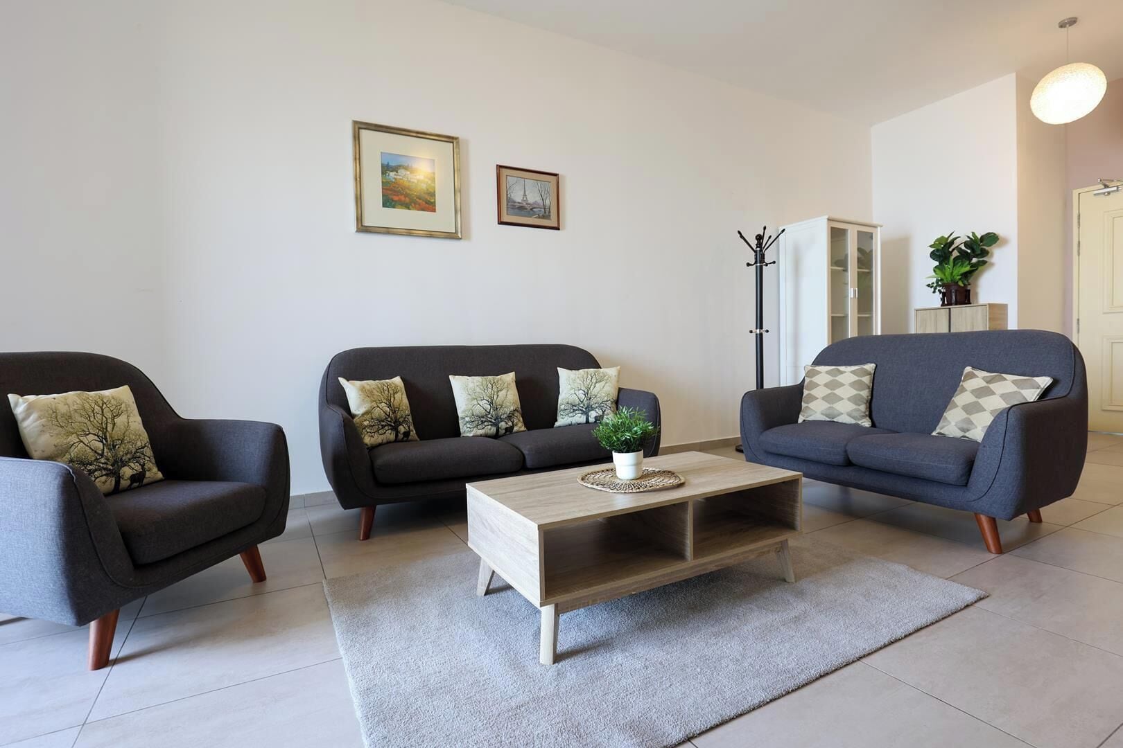 Una sala de estar moderna con dos sofás, una mesa de centro y una planta.