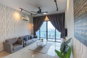Un salon moderne avec un canapé gris, une table basse et une grande fenêtre avec des rideaux.