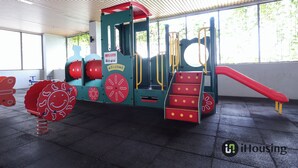 Een kinderspeelplaats met een glijbaan, klimtrappen en een rode en blauwe speelconstructie.