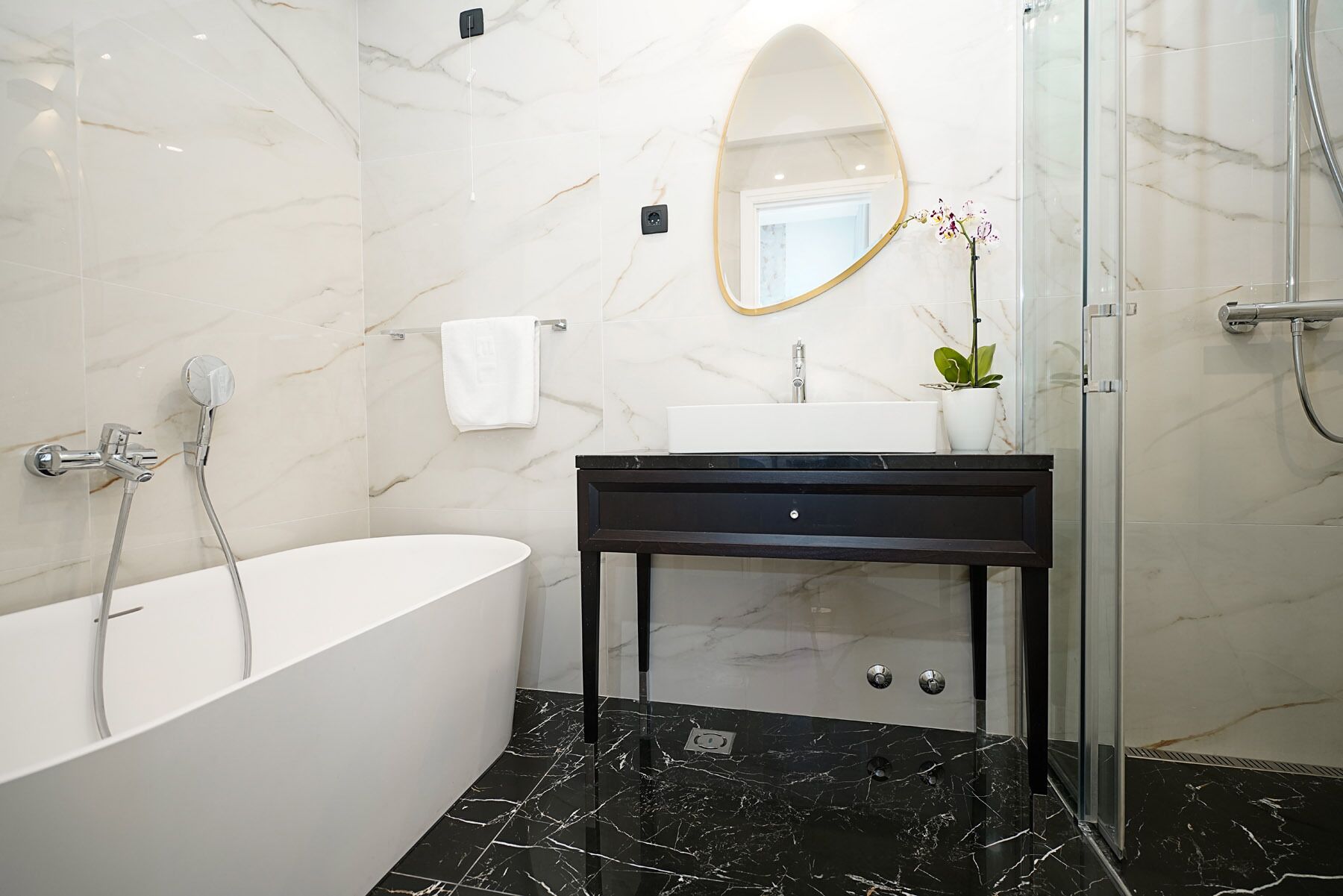 Un baño moderno con una bañera independiente, un tocador con espejo y una zona de ducha.