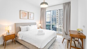 Un hotel moderno con una cama grande, un escritorio y vistas a la ciudad.