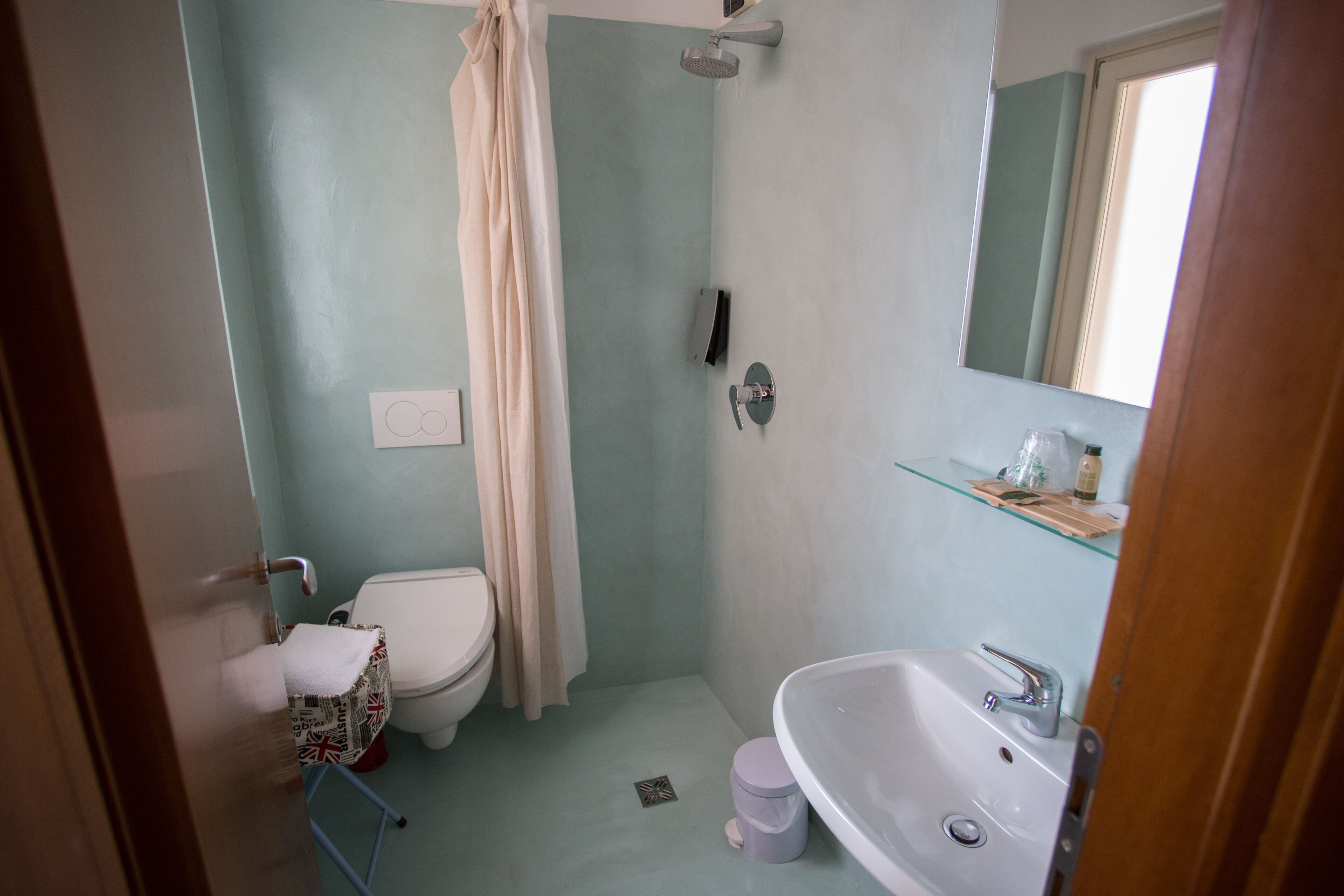 Ein Badezimmer mit Toilette, Dusche, Waschbecken und Spiegel.