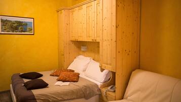 Ein Schlafzimmer mit einem Bett, einem Holzschrank und einem Nachttisch mit Telefon.