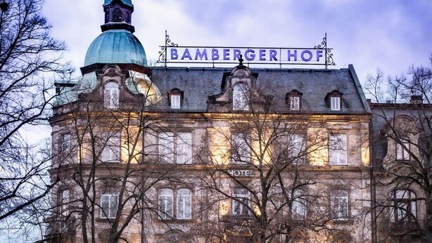 A historic building with a prominent dome and a sign reading "Bamberger Hof".
