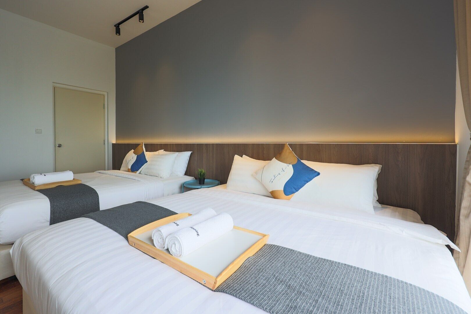 Una habitación de hotel con dos camas, una mesita de noche y una puerta.