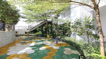 A courtyard with a colorful hexagonal tile floor, a staircase, and a tree.
