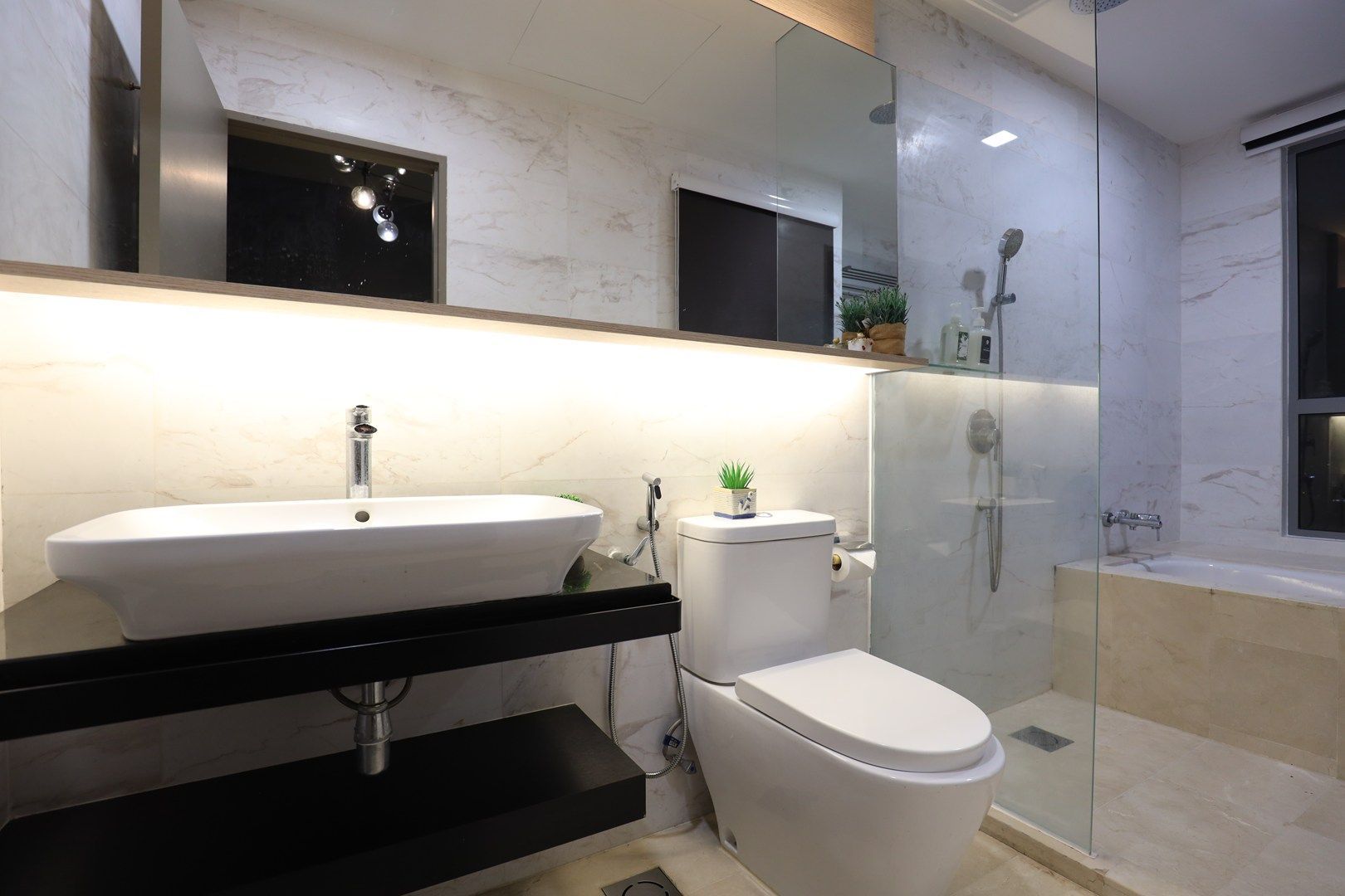 A modern bathroom with a white sink, toilet, and glass-enclosed shower.