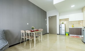 Eine moderne Küche mit Kühlschrank, Spüle und Schränken. Ein Essbereich mit Tisch und Stühlen ist ebenfalls vorhanden.