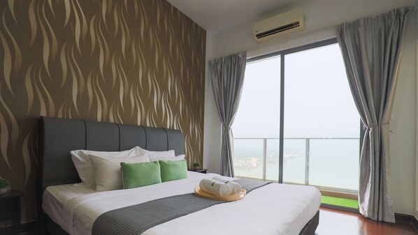 Habitación de hotel con una cama grande, cortinas grises y vistas de la ciudad a través de un amplio ventanal.