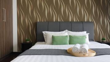 Een hotelkamer met een groot bed, een grijze hoofdbord en behang met een patroon.