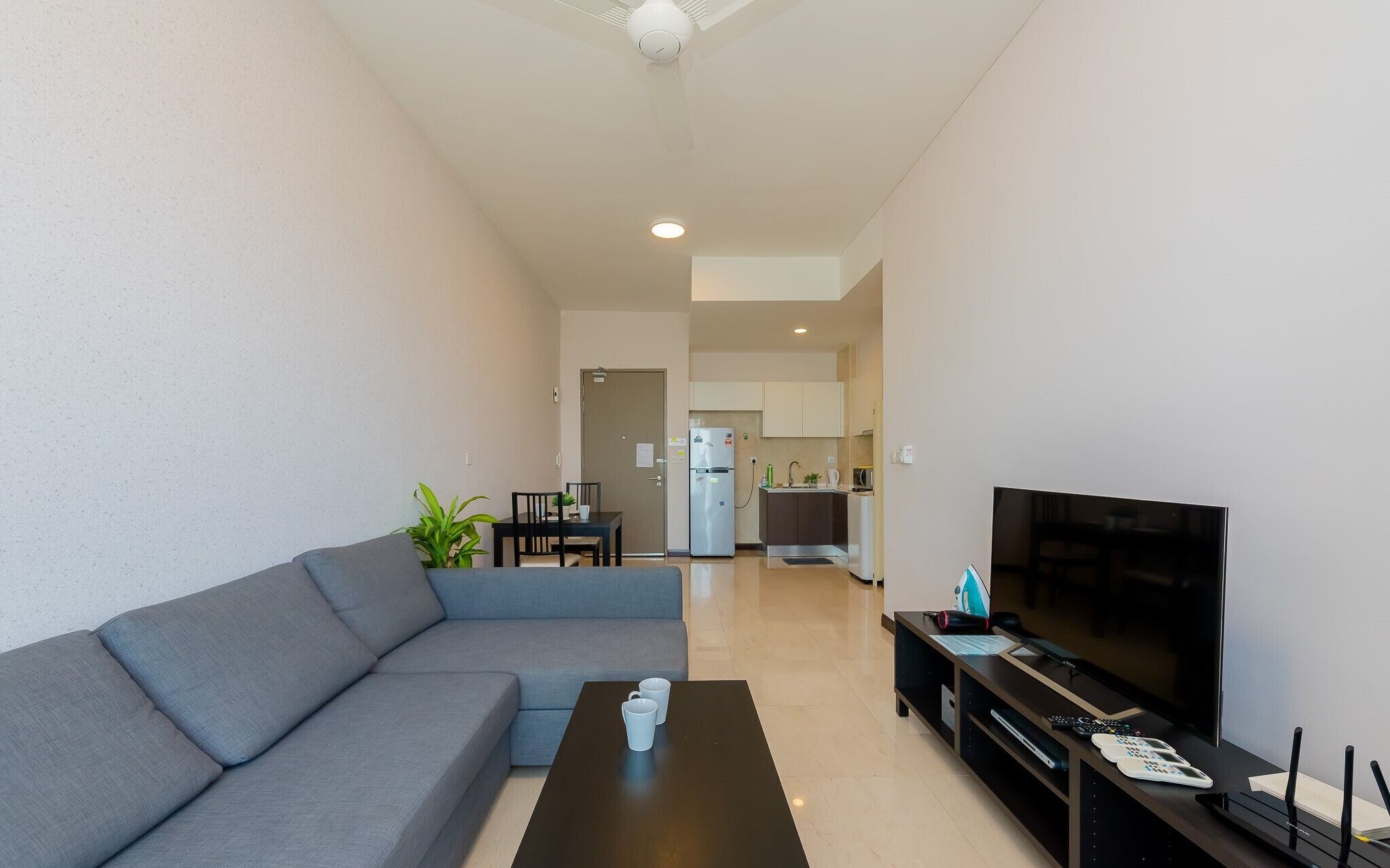 A modern living room with a sofa, a coffee table, and a flat-screen TV.