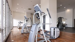 Un gimnasio con cintas de correr, elípticas y equipo de pesas.