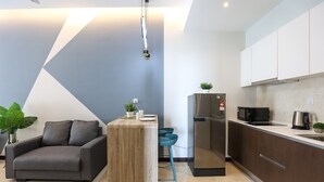 Una cocina moderna con un refrigerador empotrado, un microondas y una tetera sobre la encimera.