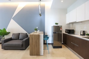 A modern kitchen with a built-in refrigerator, a microwave, and a kettle on the countertop. - Silverscape Executive Melaka by I Housing (Malacca City)