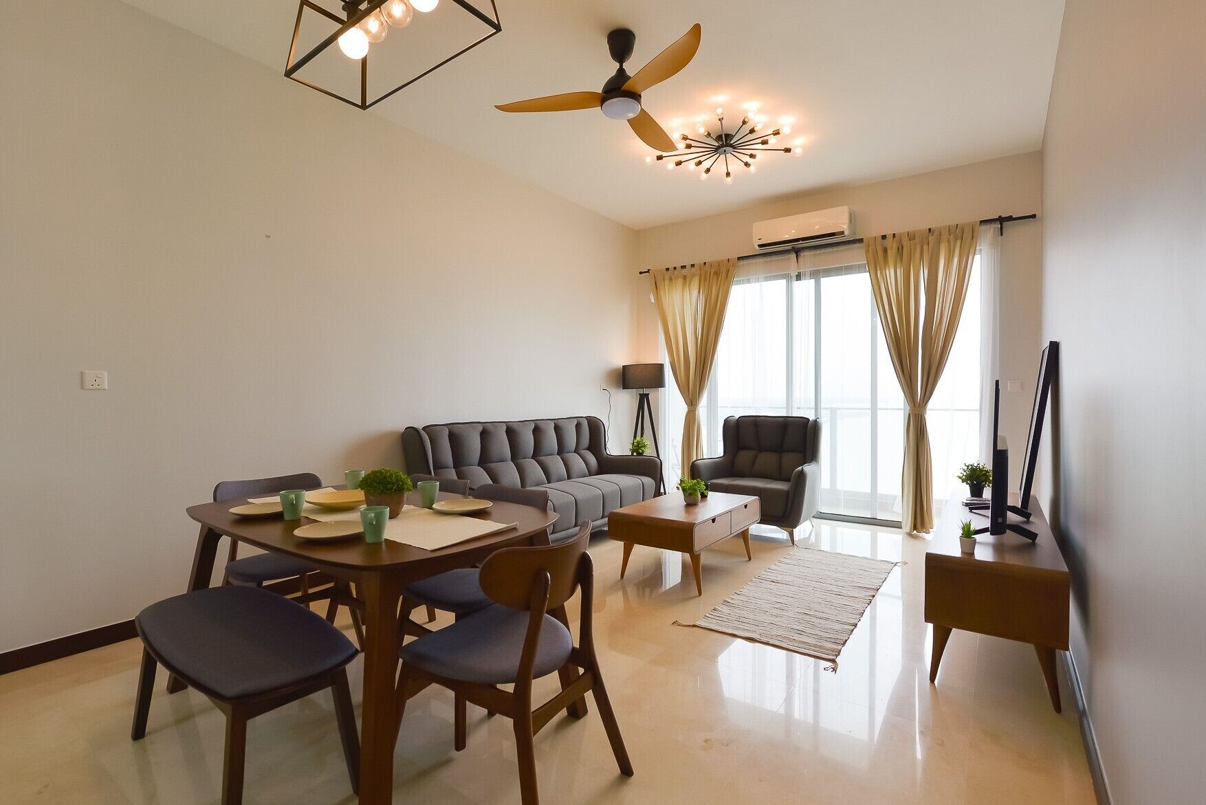 A modern living room with a sofa, dining table, chairs, a coffee table, a floor lamp, a ceiling fan, and a TV.