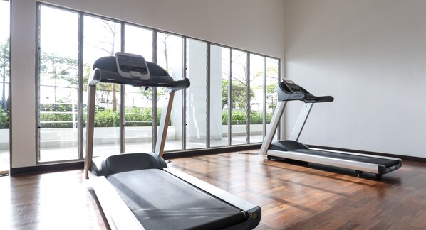 A gym with two treadmills, large windows, and a wooden floor. - Silverscape Executive Melaka by I Housing (Malacca City)