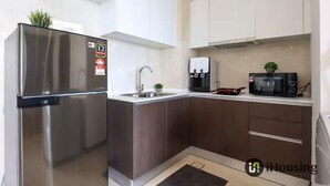 Una cocina moderna con electrodomésticos de acero inoxidable, un fregadero y un microondas.