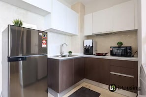 A modern kitchen with stainless steel appliances, a sink, and a microwave. - Silverscape Executive Melaka by I Housing (Malacca City)