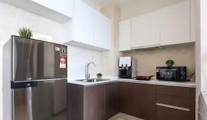 Una cocina moderna con electrodomésticos de acero inoxidable, un fregadero y un microondas.