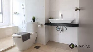 Un ba ño moderno con inodoro, lavabo y ducha.