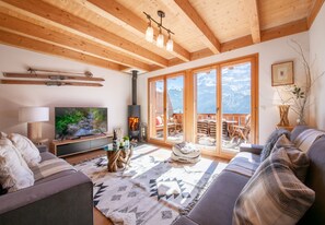 A modern living room with a fireplace, large windows, and a cozy seating area.