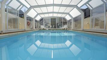 Indoor pool, open 10:00 AM to 7:00 PM, pool umbrellas, pool loungers