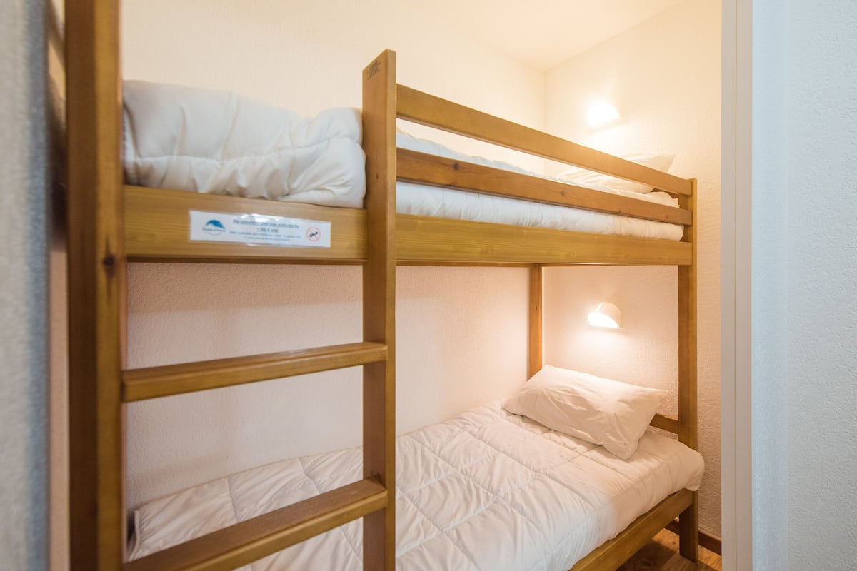 Una cama litera con un cartel en la cama superior.