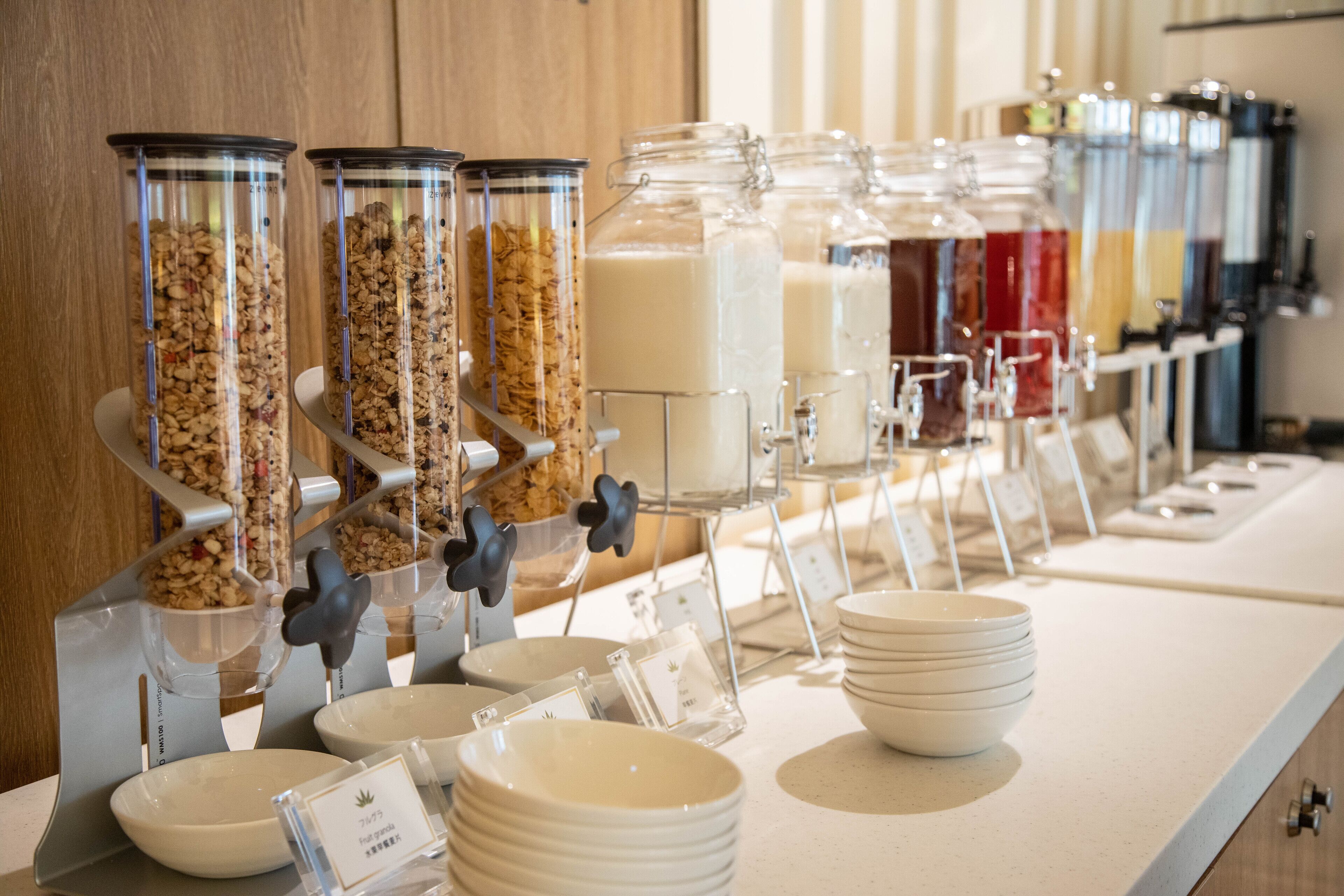 Un buffet avec différents distributeurs et récipients contenant de la nourriture.