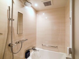 A modern bathroom with a bathtub, a handheld showerhead, and a wall-mounted towel rack.