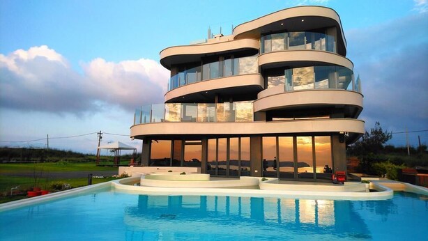 A modern multi-story building with a pool in front. - Laguna Villas & Resorts (Magong)