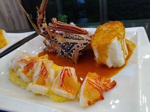 A seafood dish with lobster tail, shrimp, and a piece of bread. - Laguna Villas & Resorts (Magong)