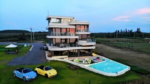 A multi-story building with a pool and outdoor seating. - Laguna Villas & Resorts (Magong)