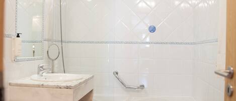 A bathroom with a marble sink, a bathtub, and a toilet.