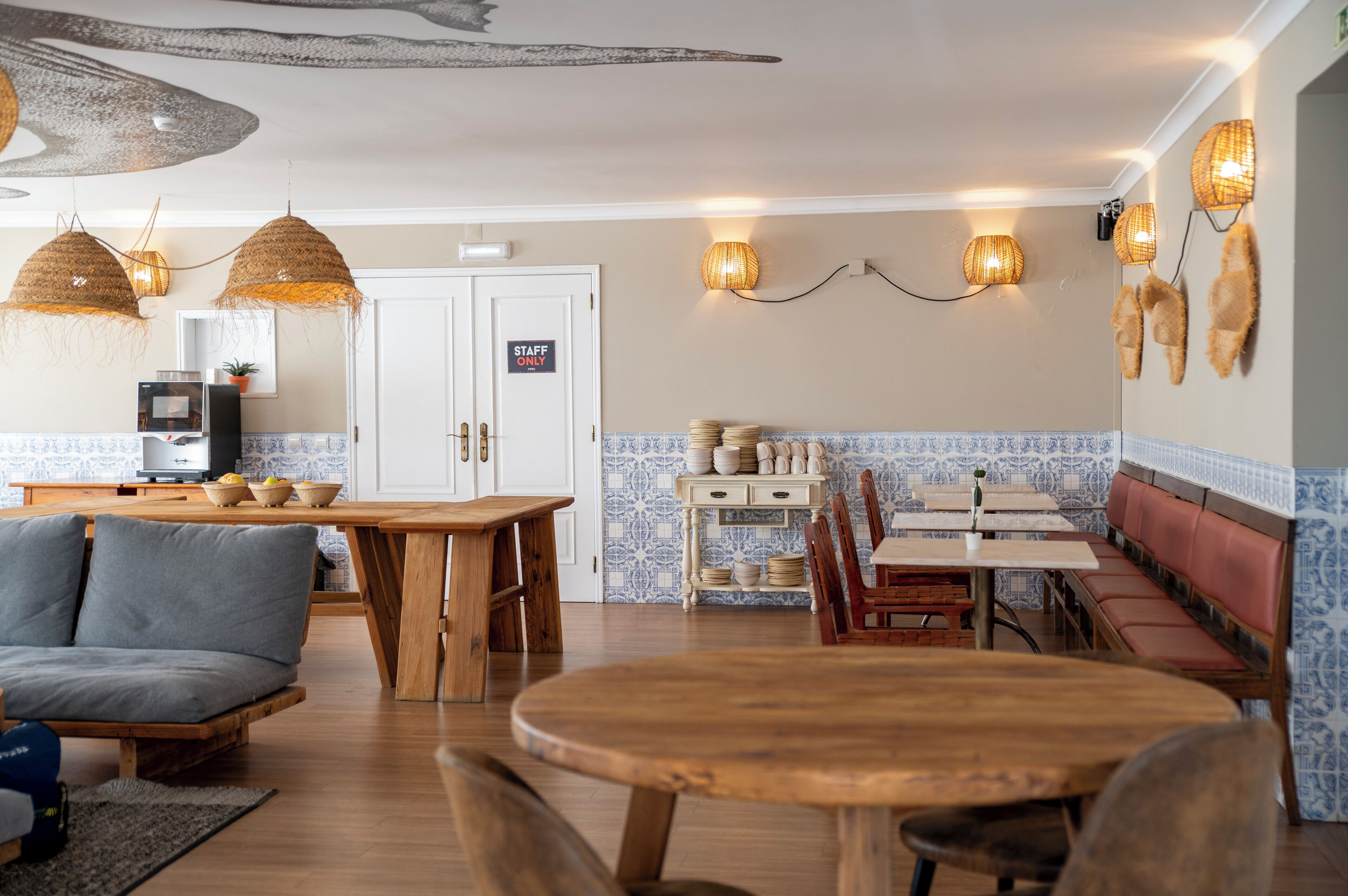Een gezellig restaurant met houten meubels, een bank en een eethoek met tafels en bankjes.