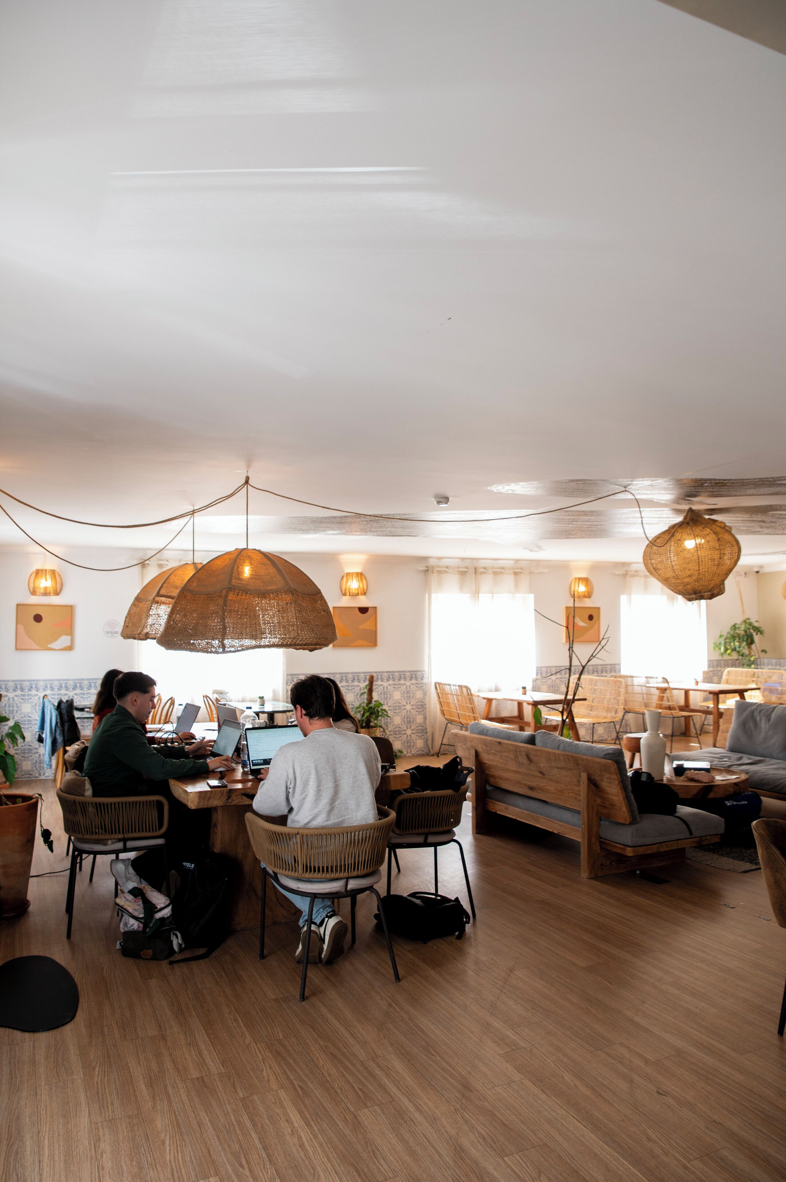 A cozy dining area with wooden furniture, pendant lights, and a view of the outdoors.