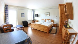 A bedroom with a wooden bed, a desk, a chair, and a television. - Haus Budinger Ferienwohnung Appartements (Alf)