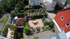 A residential area with a patio, outdoor seating, and a small garden. - Haus Budinger Ferienwohnung Appartements (Alf)