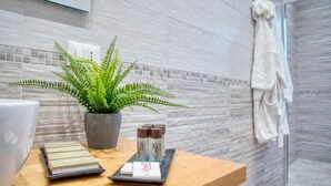 A bathroom with a wooden vanity, a potted fern, and toiletries. - B&B Gianmarti Suite (Lecce)