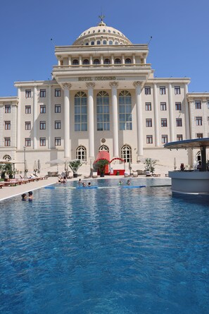 A large hotel with a central pool area, multiple swimming pools, and a grand building with a dome and columns. - Hotel Colombo (Berat)