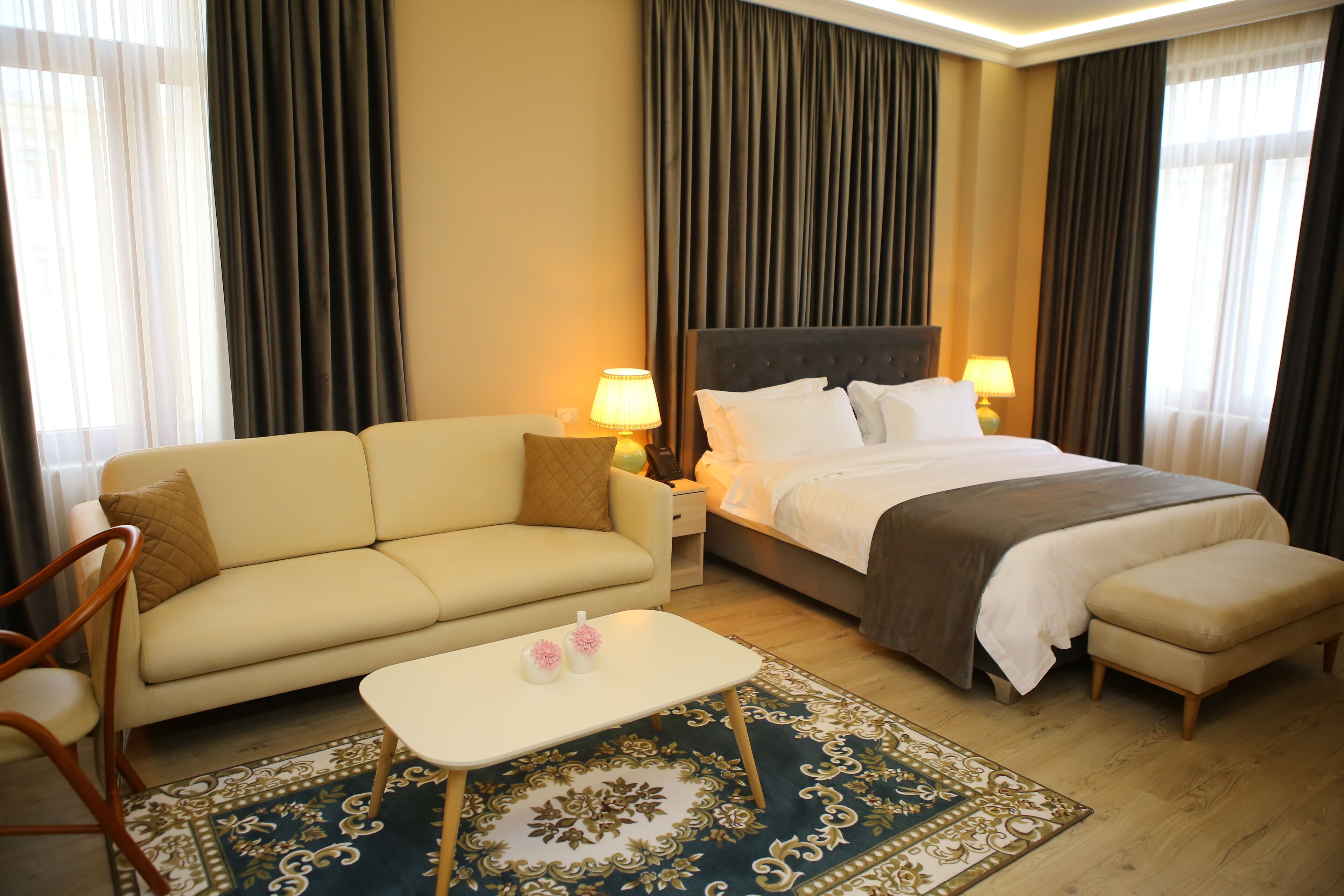 Une chambre d’hôtel avec un lit, un canapé, une petite table et une chaise.