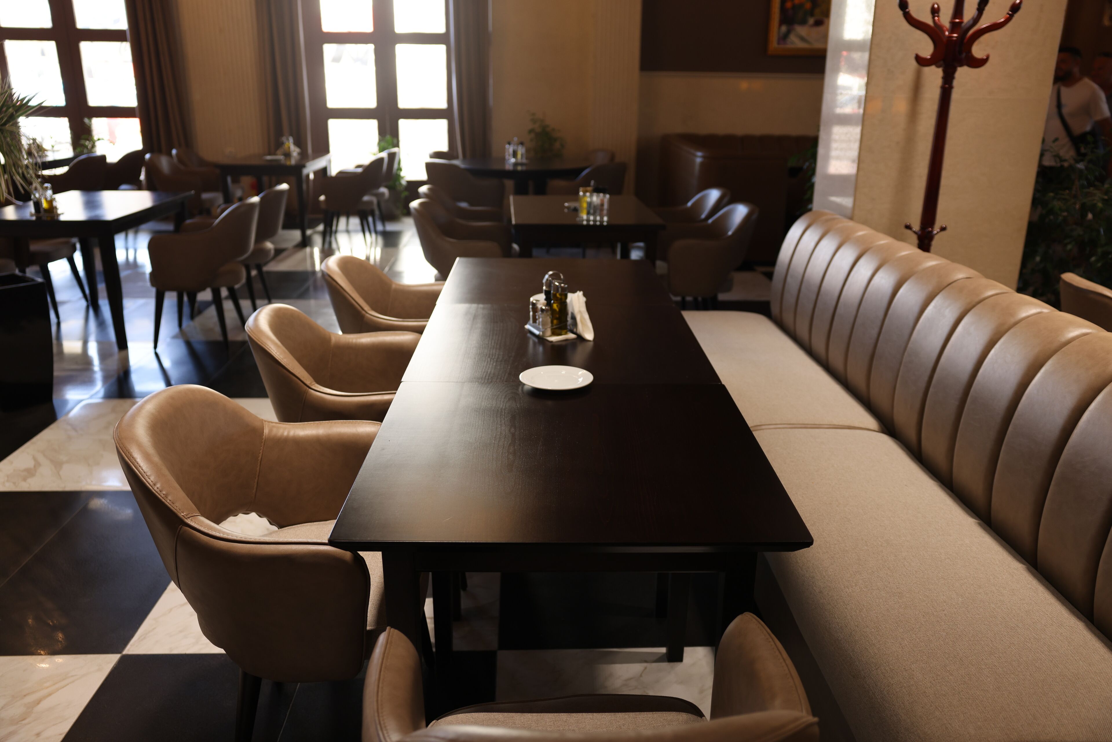 A dining area with a long table, several chairs, and a sofa.