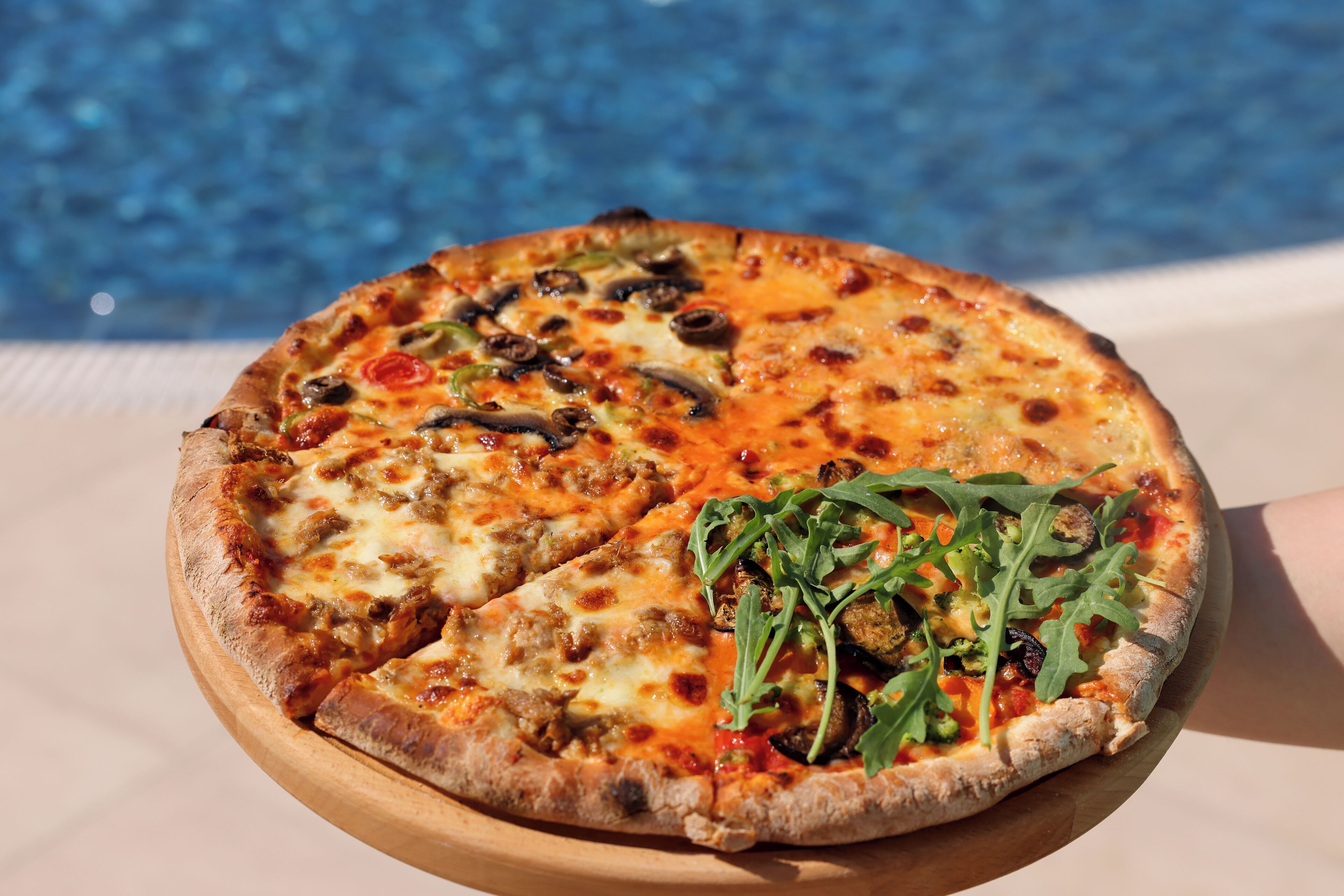 A pizza with various toppings on a wooden board.