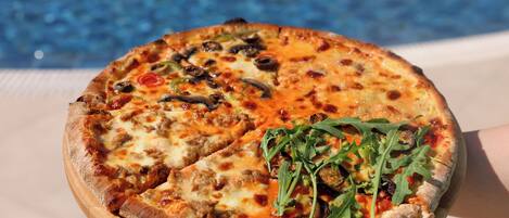 A pizza with various toppings on a wooden board.